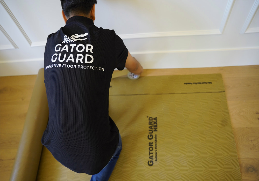 Installing Gator Guard Gold waterproof floor protection roll over hardwood flooring